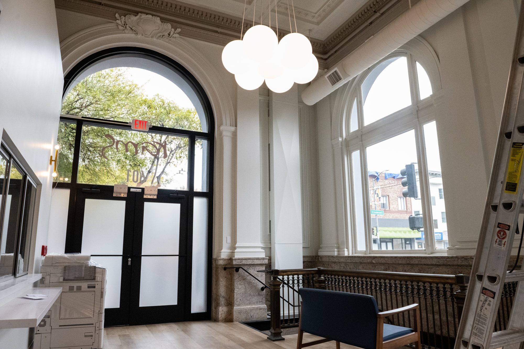 The banking hall entry: arched windows, globe chandelier and marble wainscot